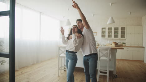 una joven pareja soñando con un nuevo interior de casa. una familia abrazándose en la cocina.