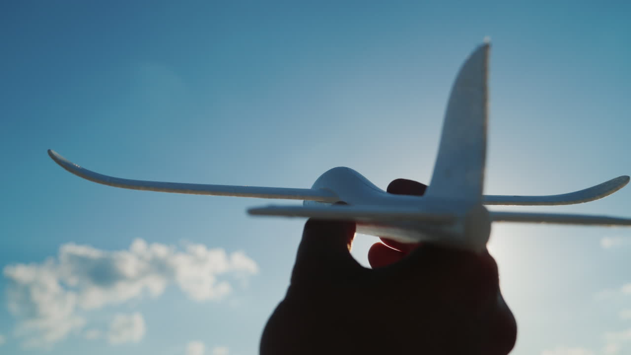 하늘을 향해 돌진하는 장난감 같은 비행기를 손에 쥐고 하늘 꿈과 좋은 창업 컨셉 4