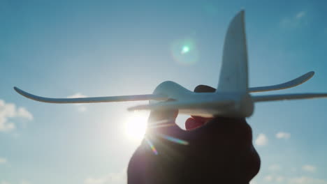 la mano sostiene un avión de juguete que se precipita hacia el cielo hacia el sueño del cielo y un buen concepto de inicio 4