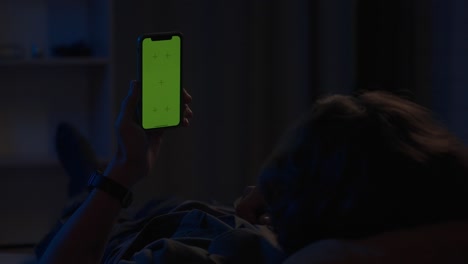 person using smartphone at night in bed