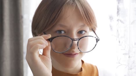 the girl looks into the camera, blinking her eyes.