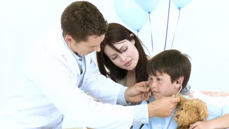 doctor jugando con un niño pequeño recuperándose en el hospital