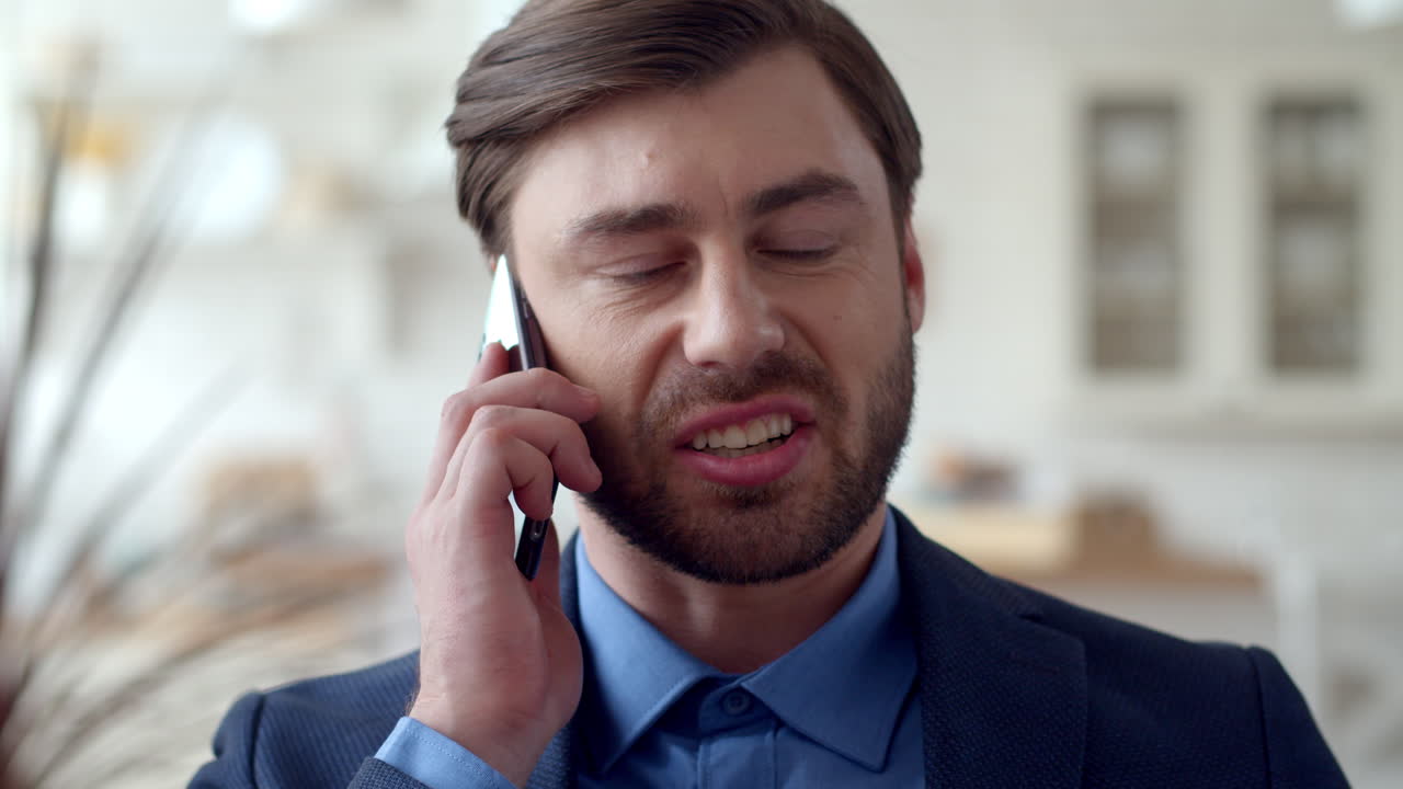 Serious business man speaking mobile phone at home office. Guy talking phone.