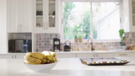 close up of bowl of bananas lying on table in kitchen