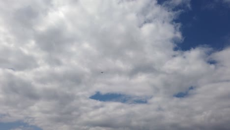 Extreme-wide-of-air-trike-flying-through-clouds-from-beach-on-a-fine-day