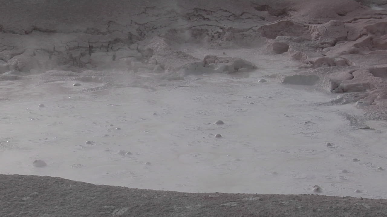 un pozo de lodo gris burbujea en el parque nacional de yellowstone