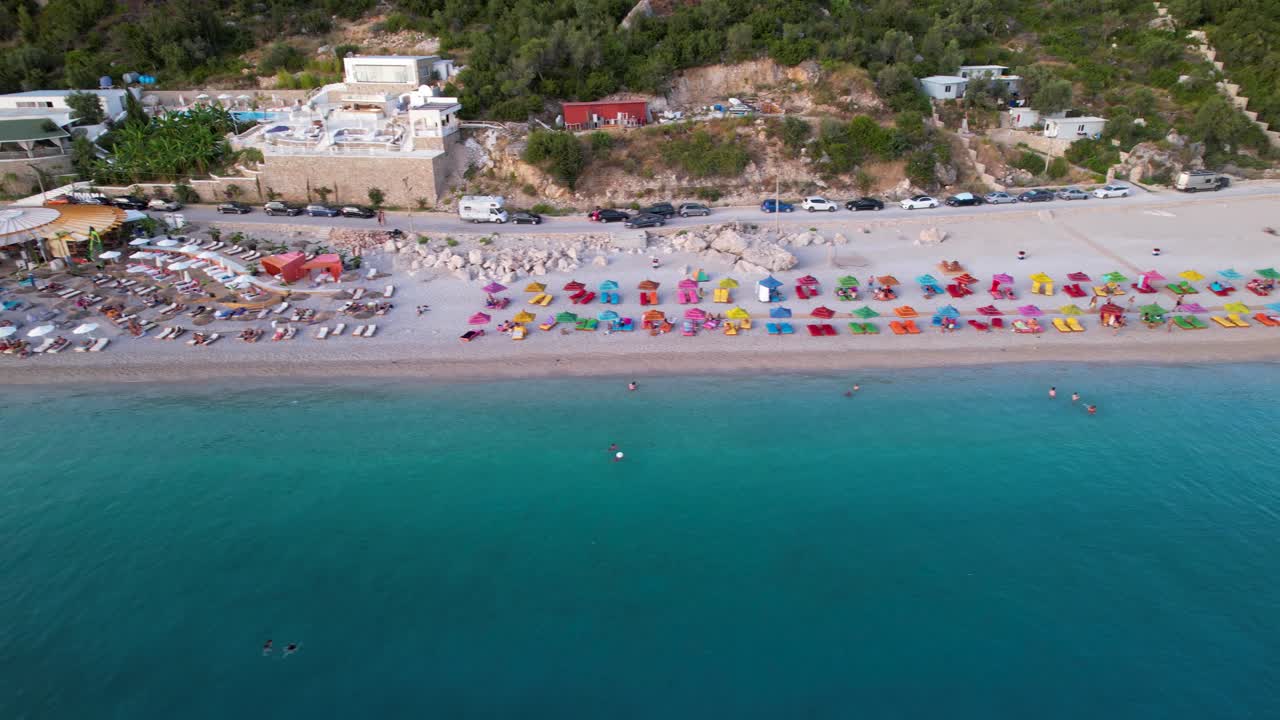 Beautiful beach with bars and umbrellas near turquoise sea water in Mediterranean coast of Albania