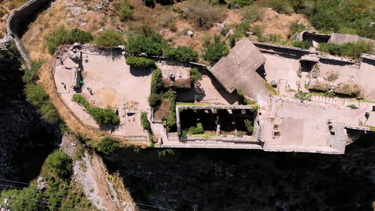 Karadağ'da ünlü bir cazibe merkezi olarak turistler dağdaki kale duvarlarını ziyaret ederken Kotor Kalesi'nin dönen kuş bakışı görünümü