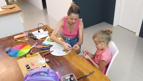 madre e hija haciendo artesanía juntos