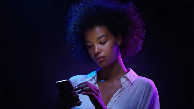 Contemplation in Light: A Young Woman Engaged with Her Smartphone, Bathed in Atmospheric Colors and Shadows, Capturing the Essence of Modern Digital Interaction