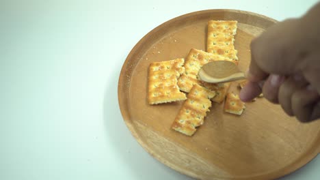 galleta de navidad sobre el plato de madera, tenedor y cuchara con fondo blanco.