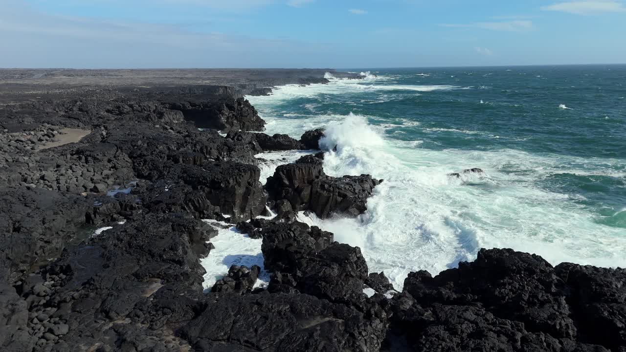 Iceland black rock sea beach aerial drone footage during a sunny day waves crash in to beach calm relaxing