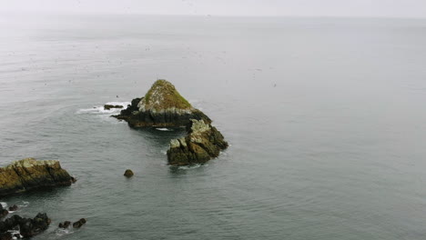 rock mountains in the middle of the sea