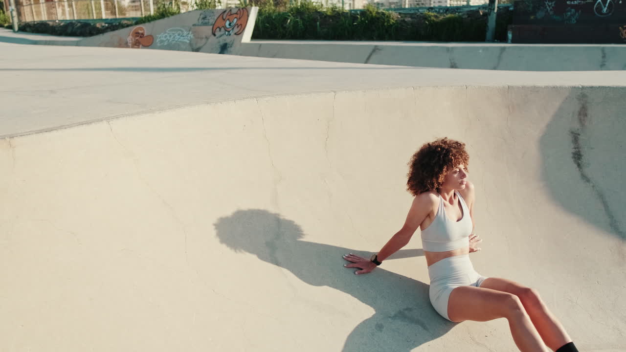Young Woman Resting in a Skate Bowl