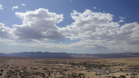 una ciudad en expansión en la cuenca del desierto de mojave con montañas en la distancia - vista aérea