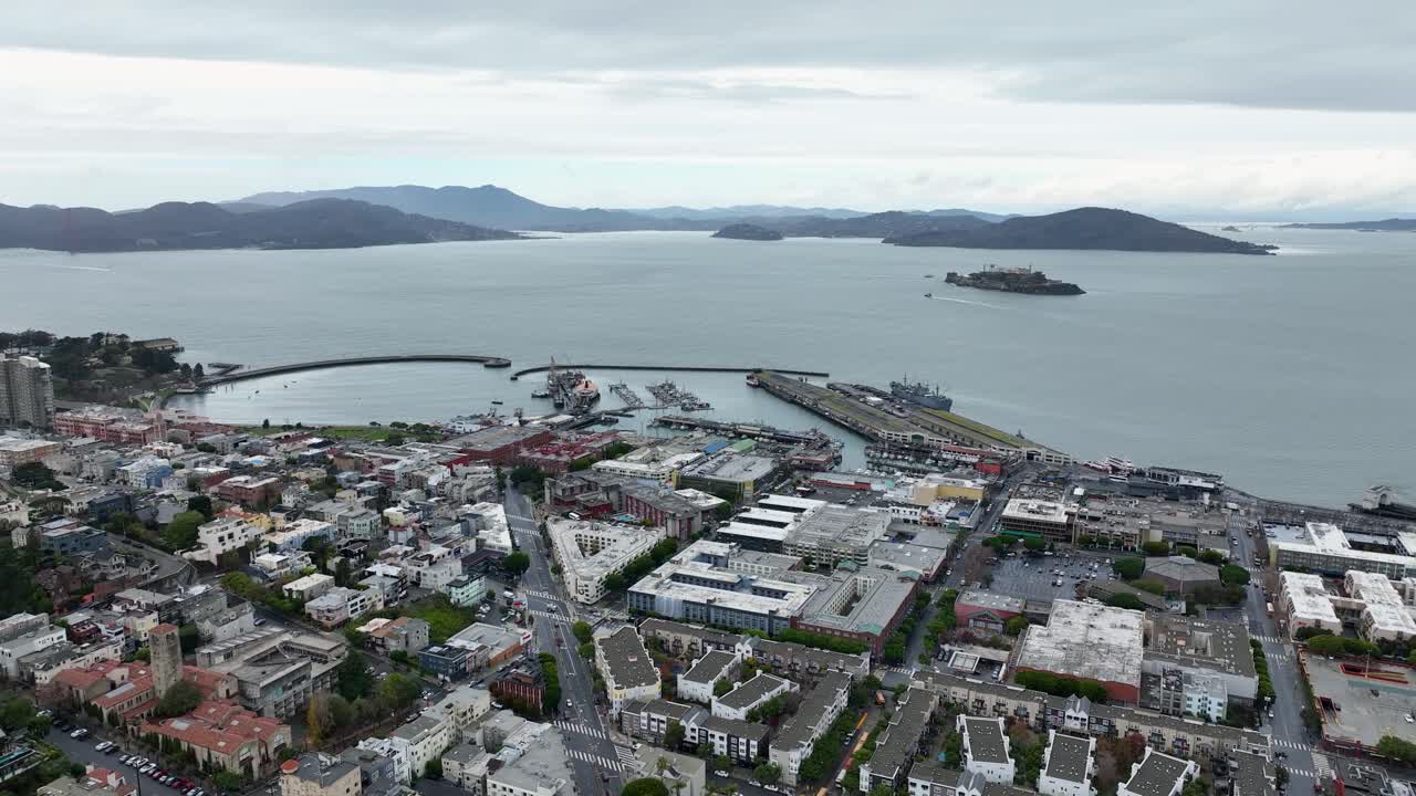 Aerial of San Francisco waterfront with bay and Alcatraz Island on overcast day