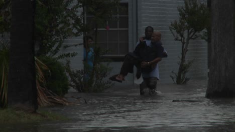 a man rescues a elderly citizen from flooding during a big storm