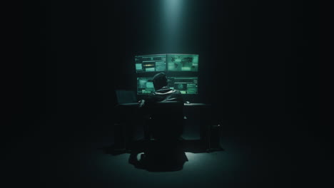 hacker in dark room monitoring screens