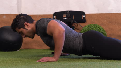 hombre musculoso realizando ejercicio de abdominales deslizando el cuerpo en el suelo entrenamiento de abdominales