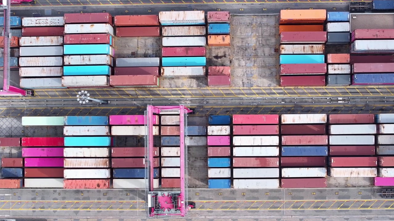 Oplev de levende farver af shippingcontainere stablet højt i en travl fragthavn. Kraner flytter varer med ekspertise, orkestrerer strømmen af international handel og sikrer rettidig levering.