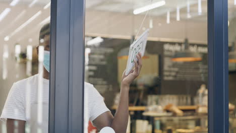 business owner adjusting open/closed sign