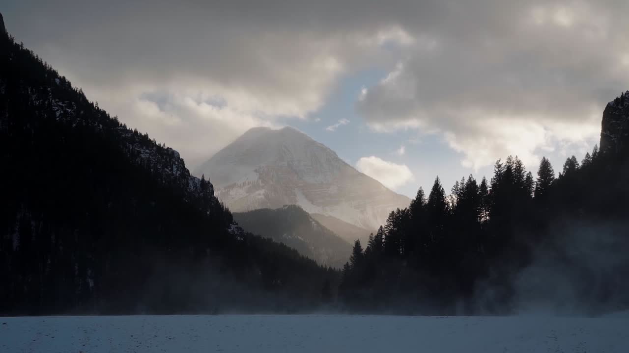 hermoso paisaje nevado de invierno del monte timpanogos en el fondo rodeado por un bosque de pinos durante la puesta de sol desde el lago congelado del embalse de tibble en el cañón de la bifurcación americana, utah