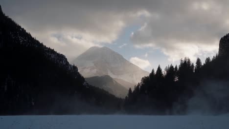 Hermoso-Paisaje-Nevado-De-Invierno-Del-Monte-Timpanogos-En-El-Fondo-Rodeado-Por-Un-Bosque-De-Pinos-Durante-La-Puesta-De-Sol-Desde-El-Lago-Congelado-Del-Embalse-De-Tibble-En-El-Cañón-De-La-Bifurcación-Americana,-Utah