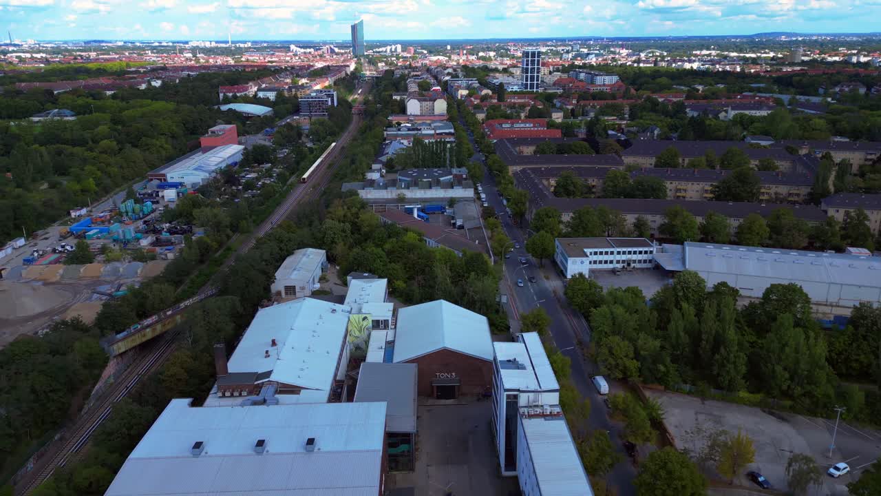 Aerial view of a cityscape with buildings, trees, railroads and streets