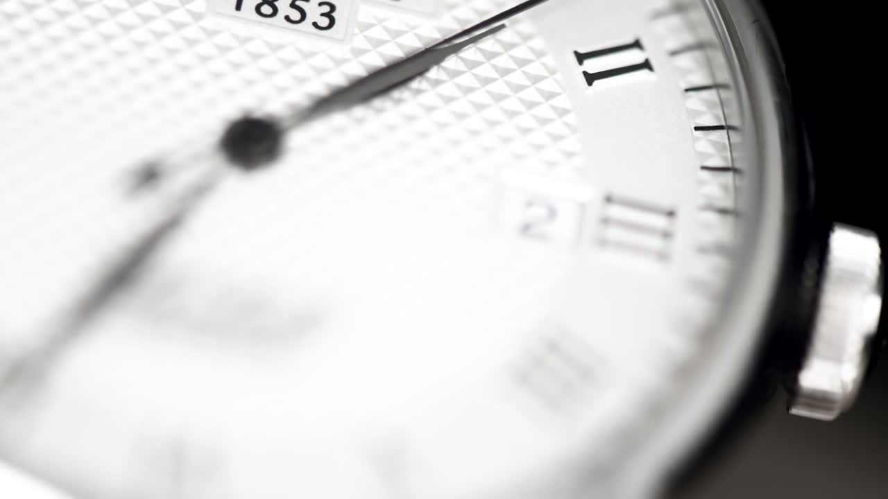 Close up of a round metallic hand watch, macro moving arrow, time running, date 4