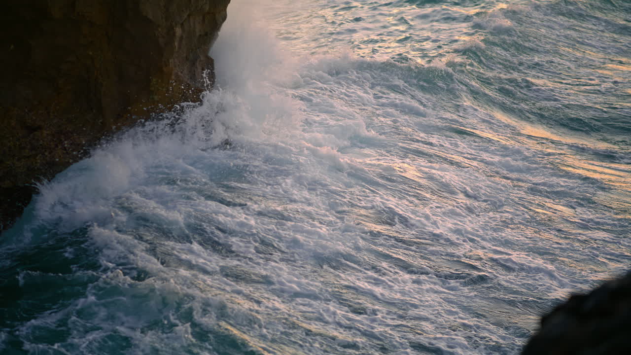 el océano salpicando la naturaleza de los acantilados en primer plano por la mañana. las olas chocan con las rocas volcánicas.