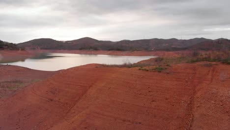 Nivel-De-Agua-Extremadamente-Bajo-En-Un-Embalse-Que-Sufre-Una-Sequía,-Como-Lo-Muestran-Los-Márgenes-áridos