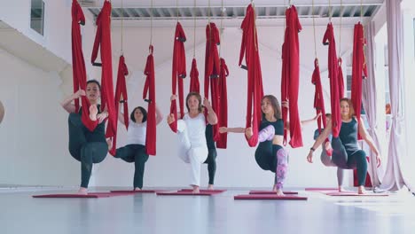 Schlankes-Frauenteam-Befreit-Beine-Aus-Fliegen-Yoga-Hängematten