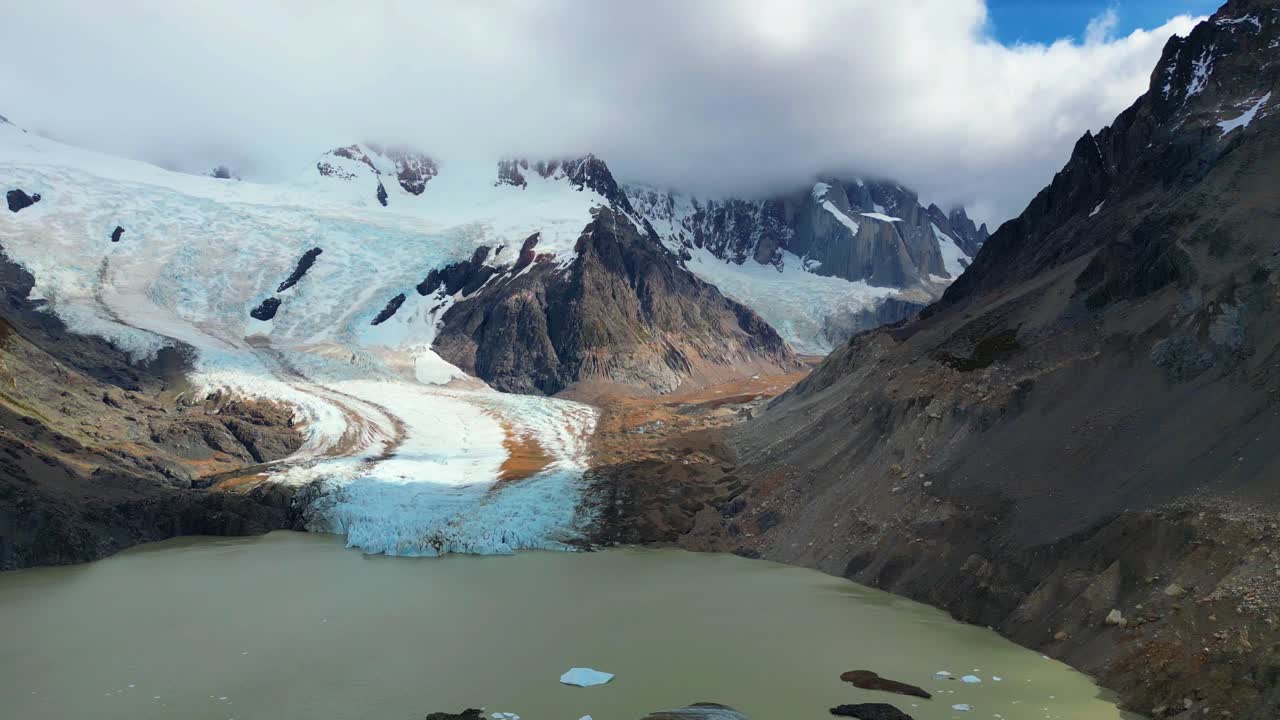 Riprese aeree con drone della Laguna Torre in Patagonia. Lastre di ghiaccio galleggiano sul freddo lago glaciale sotto un cielo nuvoloso e cupo. Una vista pacifica ma selvaggia della natura incontaminata vicino a El Chaltén, Argentina