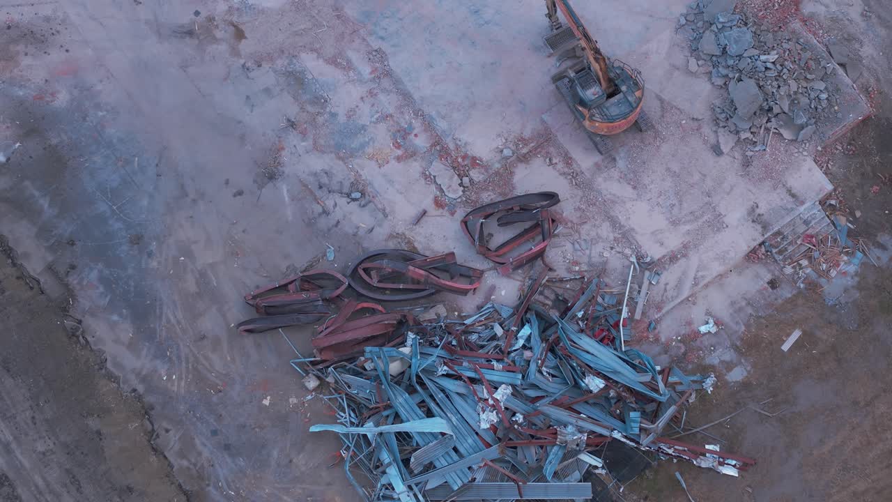 Aerial View of Demolition Site with Scrap Metal and Excavator