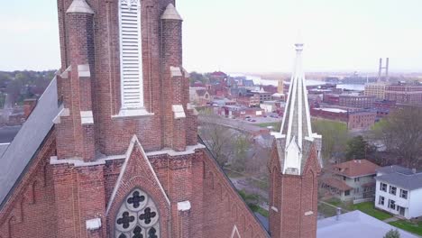 Toma-Aérea-Ascendente-Sobre-La-Pequeña-Ciudad-De-América-Iglesia-Revela-Burlington-Iowa-Con-Fondo-Del-Río-Mississippi