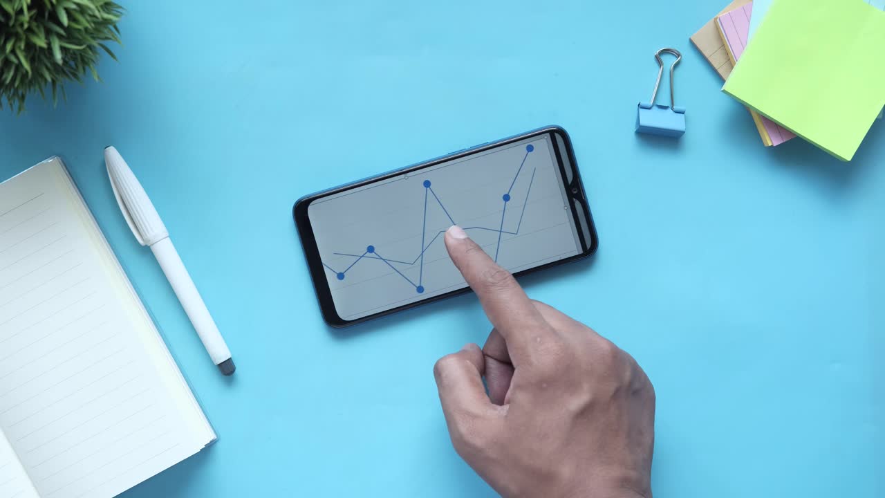 Mano che indica un grafico su uno smartphone