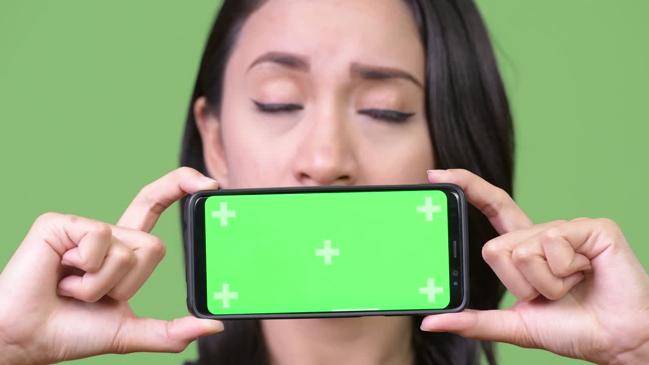 젊은 아름다운 아시아 사업가 여성이 전화를 보여주고 있습니다.