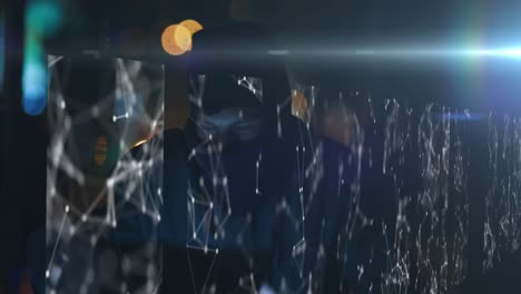 multiple screens showing webs of connections over caucasian male hacker, wearing a balaclava, using