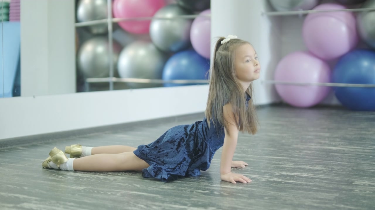 Menina praticando alongamentos de yoga em um estúdio de fitness