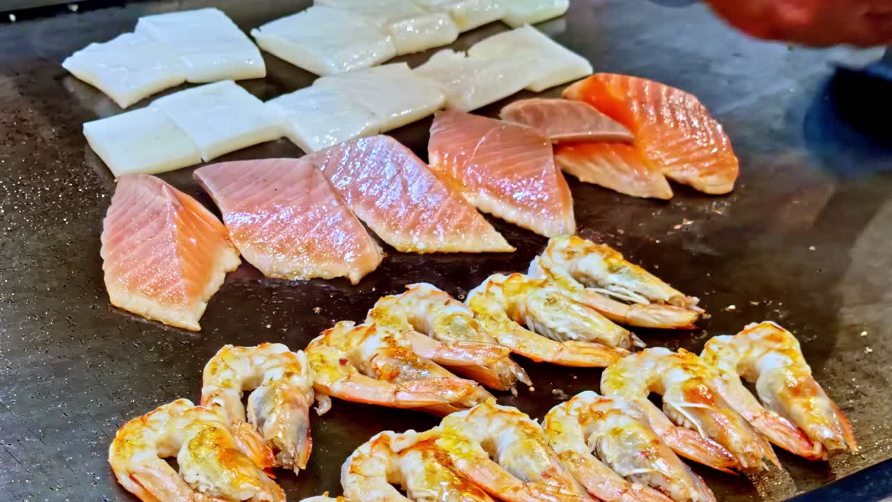 Street vendor grilling seafood skewers at Sharm El Sheikh night market, shrimp and fish filets