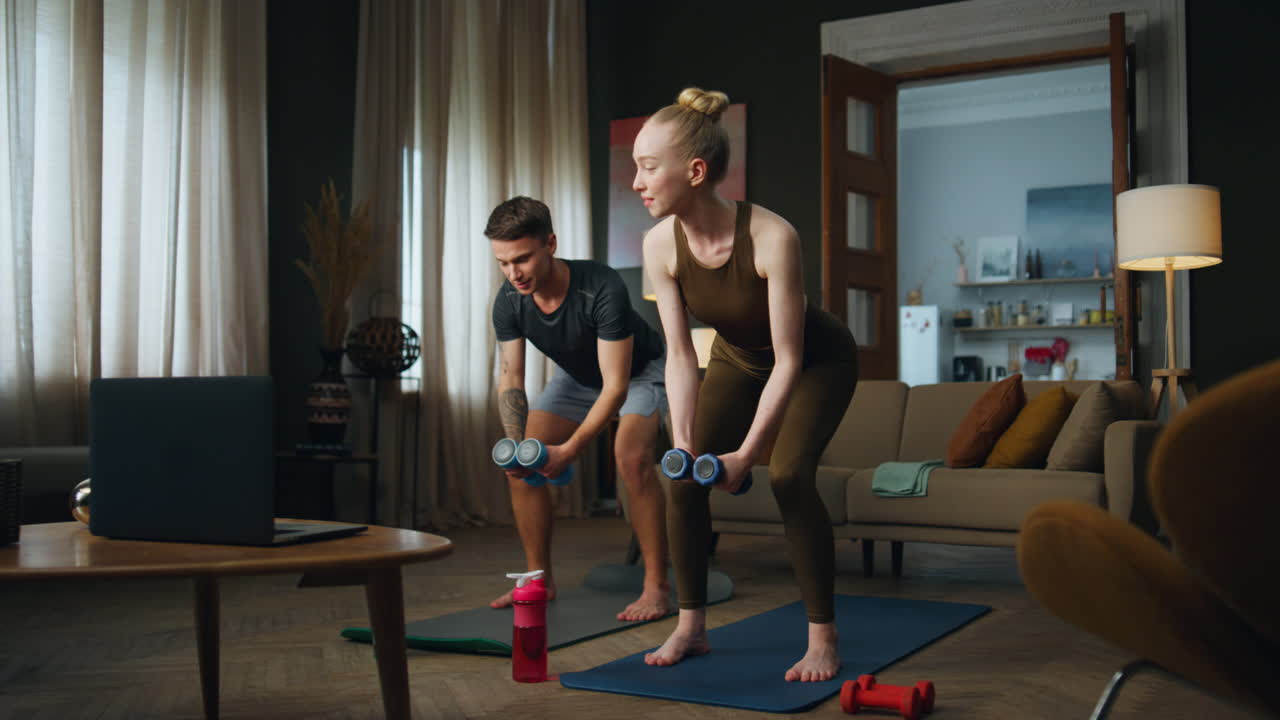 Family training dumbbells home. Couple making sport exercises for strong arms.