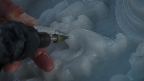 Hands-of-sculptor-carving-white-marble-stone-using-hand-tool,-close-up-shot,-Da-Nang-city,-Vietnam