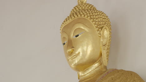 close-up shot of a bust golden sculpture of the buddhist deity gautama buddha in a temple in bangkok, thailand