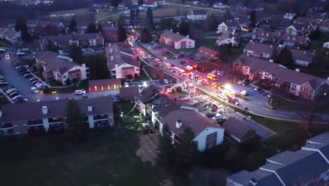 volando sobre el incendio de una casa de condominios con camiones de bomberos y ambulancias