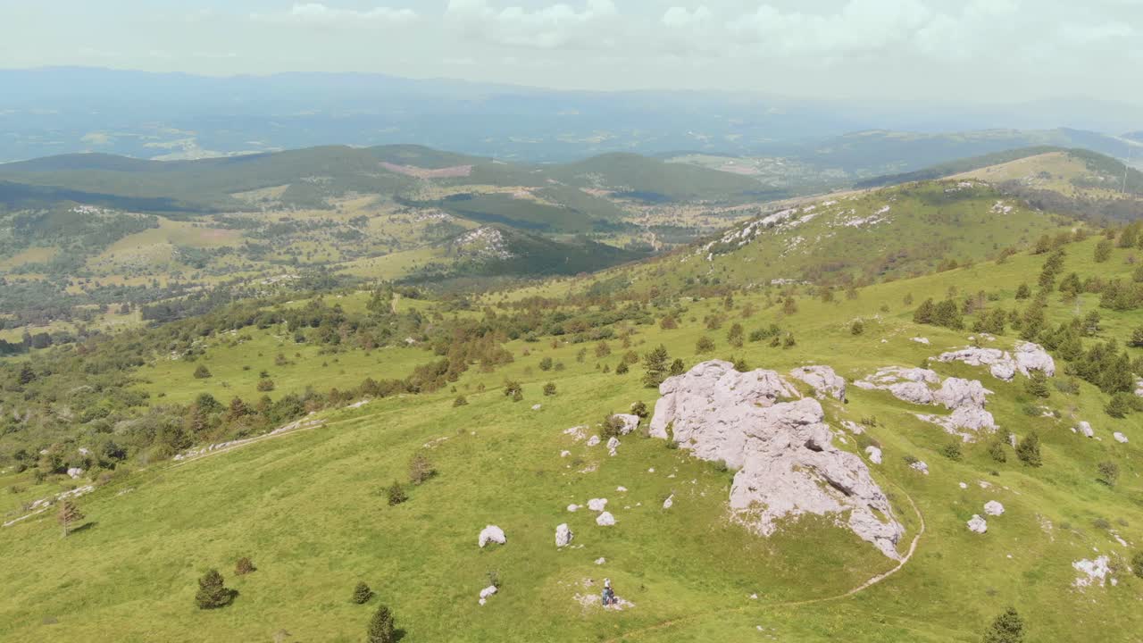 크고 무성한 녹색 산 너머의 풍경 느린 드론 보기, 더 넓은 범위의 산 시리즈를 보여줍니다.