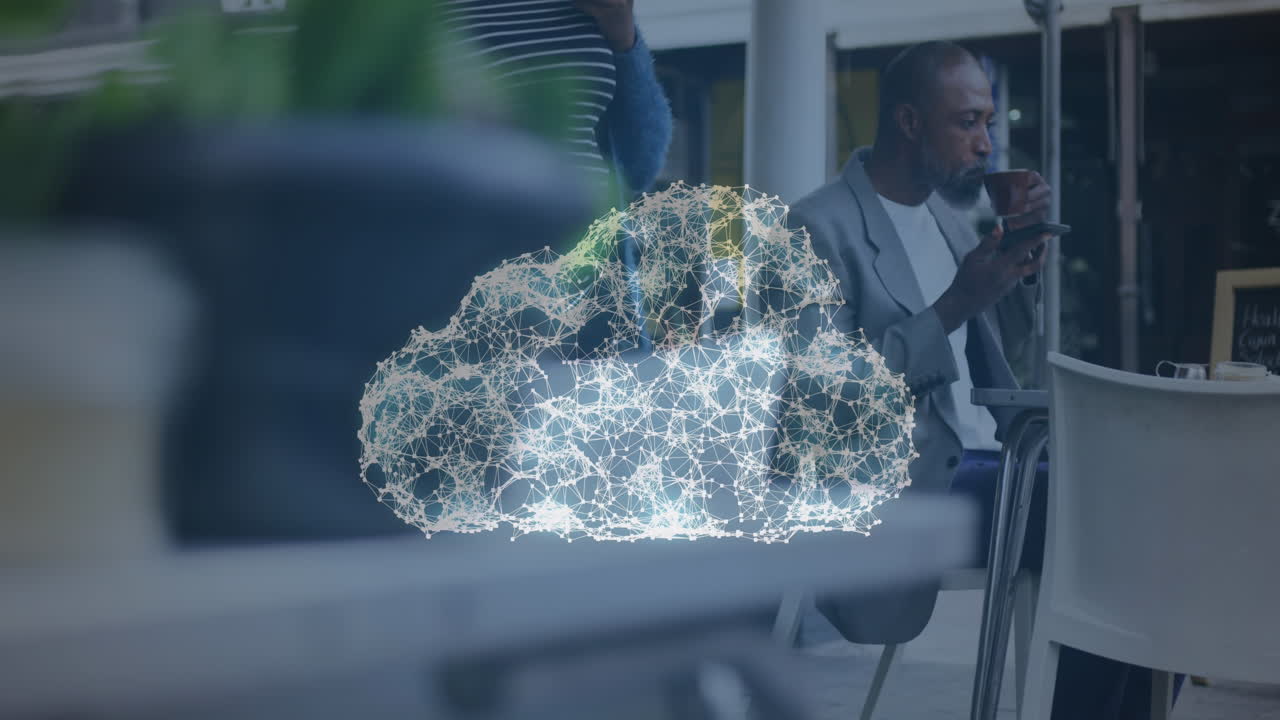 Animation of digital cloud icon over man having coffee and talking on smartphone