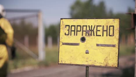 firefighters in protective gear near a warning sign for hazardous materials