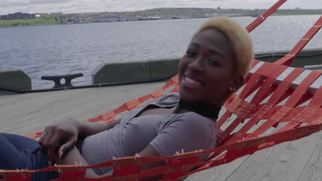 una hermosa mujer joven tendida en una hamaca a lo largo del paseo marítimo de halifax