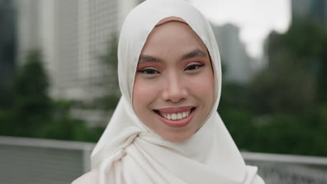 smiling woman wearing hijab in city