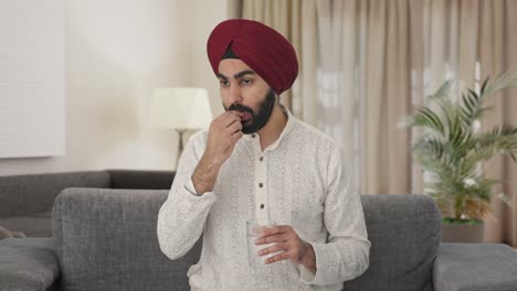 hombre indio sikh tomando medicina